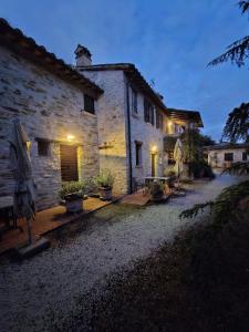 a stone building with umbrellas in front of it at Le Gorghe di Valmarino in Corciano