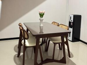 a wooden table with a vase of flowers on it at Villa Ostara Kota Batu in Batu