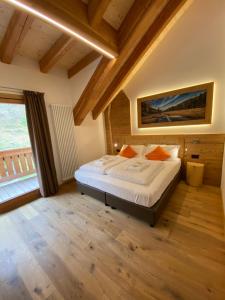 a bedroom with a bed and a large window at Hotel Aurai in Osteria Alpina