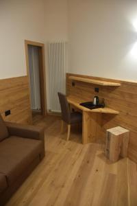 a room with a desk and a couch and a table at Hotel Aurai in Osteria Alpina