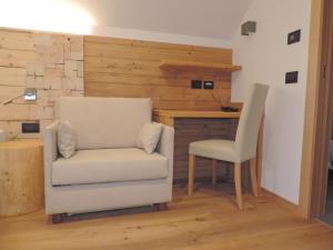 a white chair in a room with a desk at Hotel Aurai in Osteria Alpina