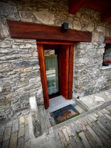 a window of a stone building with a door at La maison du faux monneyeur in Saint-Rhémy-en-bosses