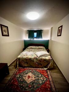 a small bedroom with a bed and a rug at La maison du faux monneyeur in Saint-Rhémy-en-bosses