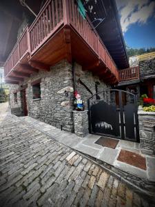 a balcony on top of a building with a gate at La maison du faux monneyeur in Saint-Rhémy-en-bosses