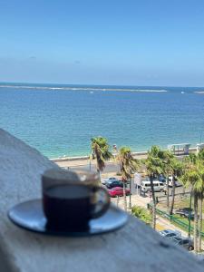 un cappello appoggiato su una sporgenza che domina una spiaggia di Acropole Alexandria Hotel ad Alessandria d'Egitto
