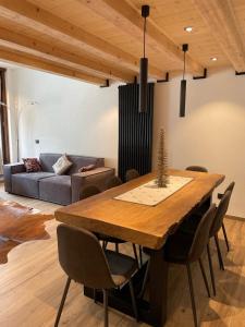 a dining room with a table and a couch at Il Sole delle Dolomiti in Campestrin