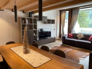 a living room with a table with a christmas tree on it at Il Sole delle Dolomiti in Campestrin