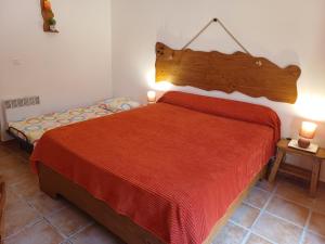 a bedroom with a bed with a red bedspread and two lamps at Chez Nat et JC in Eccica-Suarella