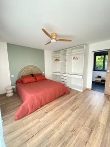 a bedroom with a bed and a ceiling fan at La Logette in Les Petites-Loges