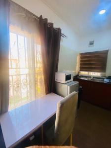 a kitchen with a table and a window with a window at Studio Apartment Wuye-City Center in Abuja +13 photos