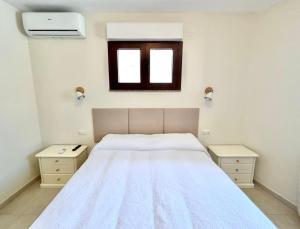 にあるB&B Magusadaの白いベッドと窓のある寝室