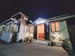 a pair of houses with plants in front of them at night at Insara Cottage in Shillong