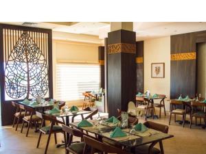 Marsa AlamOyster Bay Beach Suites k5-11的一间有桌椅和枝形吊灯的餐厅