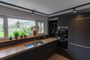 a kitchen with a sink and a large window at Freistehendes Ferienhaus Renkenmühle näher kann man am Wasser nicht wohnen in Eberbach