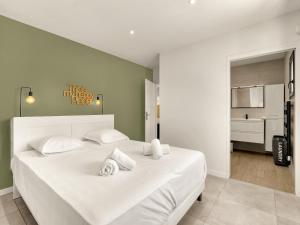 a bedroom with a large white bed with towels on it at Nouvelle Villa Harmonia Piscine Proche Montpellier et Plages in Saint-Jean-de-Védas