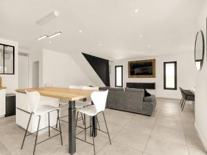 a kitchen and living room with a wooden table and chairs at Nouvelle Villa Harmonia Piscine Proche Montpellier et Plages in Saint-Jean-de-Védas +13 photos