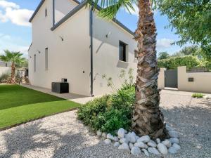a palm tree in front of a white house at Nouvelle Villa Harmonia Piscine Proche Montpellier et Plages in Saint-Jean-de-Védas