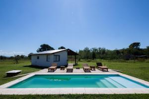 a swimming pool with chairs and a house at Mi lugar en el mundo in Villa Ciudad Parque