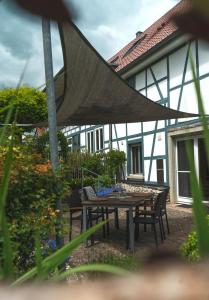 Un patio con mesa y sillas y un edificio. en Ferienwohnung Maierers Schaiere, en Gammesfeld