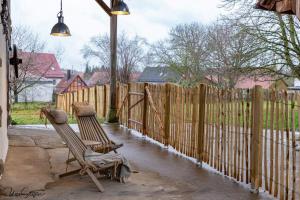 two chairs sitting on a patio next to a fence at Ferienhaus Honey Bee in Billingsbach