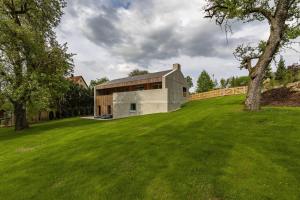 a house on a hill with a green field at Ferienhaus TierbachLodge in Herrentierbach