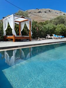 a tent and chairs next to a swimming pool at Hotel Narkissos in Archangelos