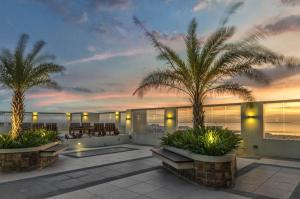a house with two palm trees on a patio at Condo Unit at La Verti Residences in Manila