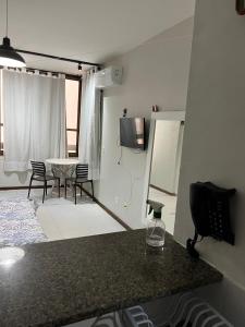 a room with a bed and a table with chairs at studio aconchegante para 02 na praia de Amaralina in Salvador