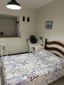 a bedroom with a bed and a desk at studio aconchegante para 02 na praia de Amaralina in Salvador +13 photos