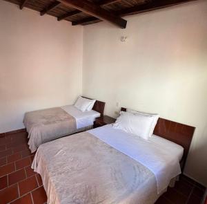 two beds sitting next to each other in a room at Hostal Rous San Gil in San Gil