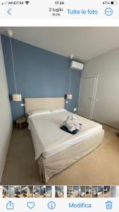 Un dormitorio con una cama con una pared azul. en Hotel Miramare, en Savona