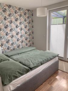 1 cama en un dormitorio con una pared y una ventana en Seaside Apartment, en Trzęsacz 5 fotos más