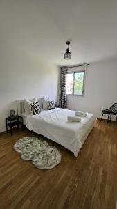 a bedroom with a large white bed with a rug at Les Reflets de Dijon in Dijon