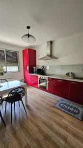 a kitchen with red cabinets and a table in a room at Les Reflets de Dijon in Dijon