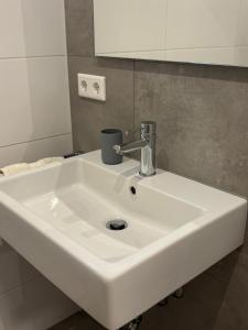 a white sink in a bathroom with a mirror at Apartment - Wohnen auf Zeit in Ursensollen