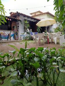 Ganesha do mar في بوزيوس: فناء مع طاولات وكراسي ومظلة