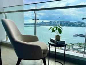 a chair and a table in a room with a large window at Homestay Sapphire Hạ Long in Ha Long