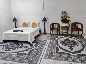 Kota BharuにあるDnRoses Innのベッドルーム1室(キングサイズベッド1台、椅子2脚付)