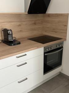 a kitchen with a wooden counter top and a stove at Apartment - Wohnen auf Zeit in Ursensollen +3 photos