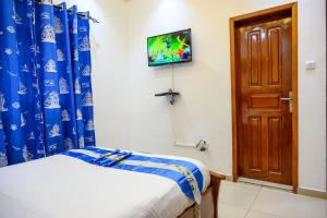 Una televisión o centro de entretenimiento en Chambre Junior - RESIDENCE BAHO - Douala Makepe BM
