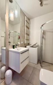 a white bathroom with a sink and a shower at Cozy Stay Apartment Szaserów in Warsaw