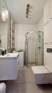 a bathroom with a shower and a toilet and a sink at Cozy Stay Apartment Szaserów in Warsaw +12 photos