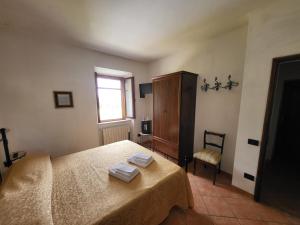 I Castagnini في بمونتيكاتيني فال دي سيسينا: غرفة نوم بها سرير عليه منشفتان