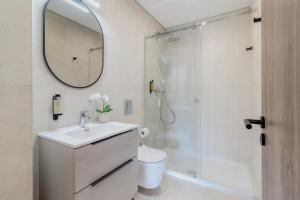 un bagno con lavandino e doccia con specchio di São Luís Faro Apartment - Algarve a Faro Altre 13 foto
