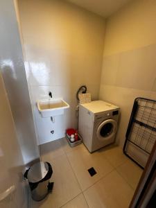 a small bathroom with a washing machine and a sink at Exclusivo Departamento! in Cochabamba