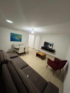 una sala de estar con un sofá y una mesa en Reserva camburi 1, en Vitória
