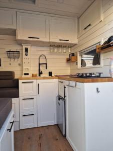 a kitchen with white cabinets and a sink at Sprinter Camper Albania Rental in Tirana