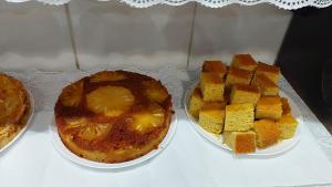 a table topped with two plates of cake and desserts at Pousada Ouro Preto in Ouro Preto