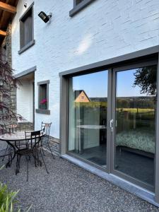 a patio with sliding glass doors and a table at La Halte in Malmedy
