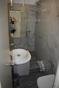 a bathroom with a sink and a toilet and a mirror at Portobelis Apartments in Sitia